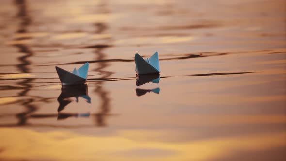 Two blue paper ships on water outdoors