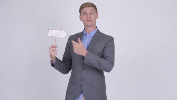 Young Handsome Businessman Holding Not Drunk Enough Paper Sign