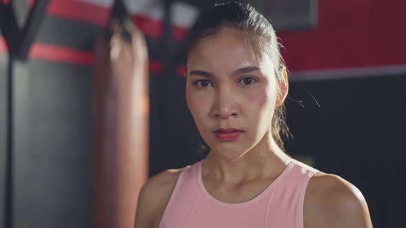 Portrait of Asian young female athlete or sportswoman standing in the dark of stadium after exercise