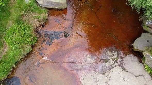 Meandering  moorland stream in the Derbyshire Peak District with water flowing over small and large