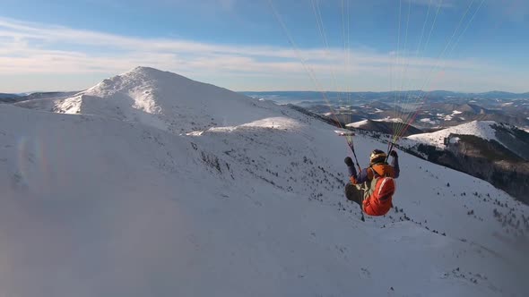 Beauty of Free Paragliding Flight above Snowy Winter Mountains
