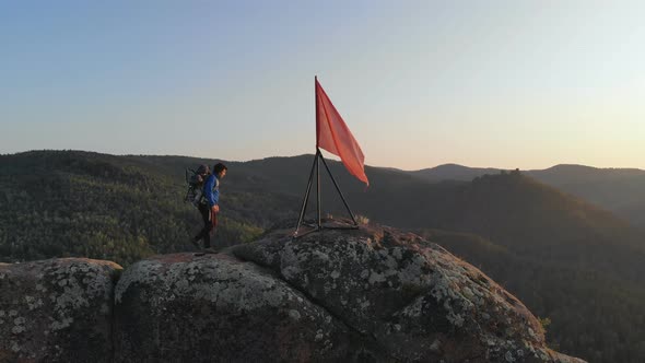 A Young Man Trekking with Her Baby Pointing Somewhere. alt
