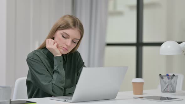 Young Woman with Laptop Taking Nap at Work 