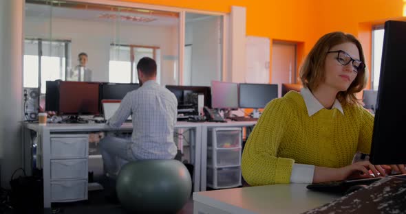 Young caucasian female executive working on desktop pc at desk in modern office 4k