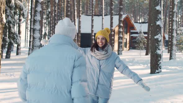 Young Cheerful Couple in a Winter Forest Man and Female Take a Photo on Camera Against the
