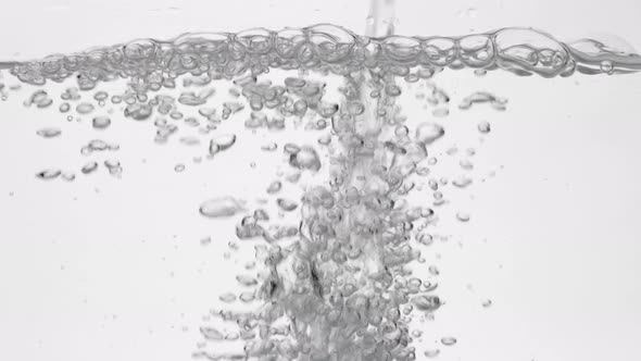 Pouring drinking water in glass over white