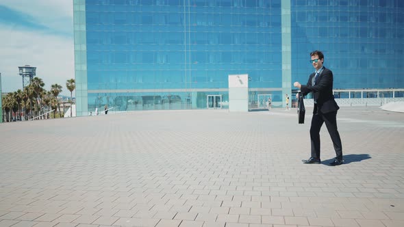 Flexible and cool businessman doing acrobatic tricks outdoor.