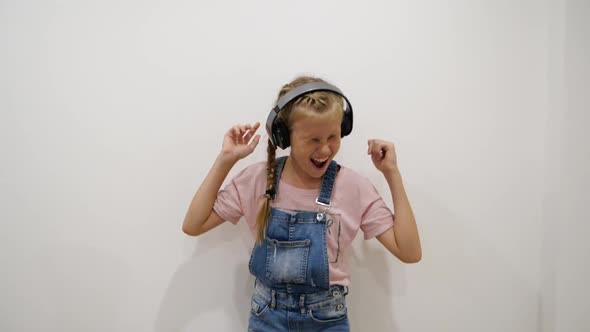 Pretty Young Girl Having Fun Smiling Dancing with Headphones Against White Background