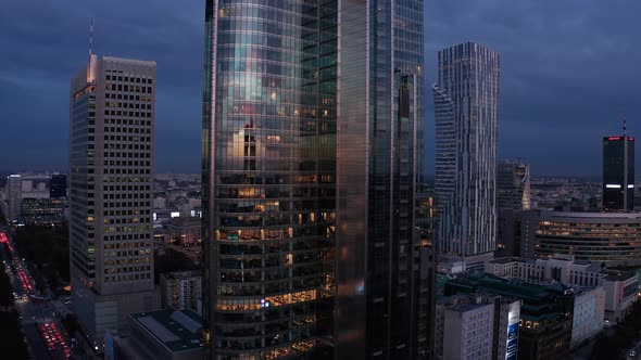 Rising Shot of Modern Futuristic Tall Skyscraper with Glossy Glass Facade Reflecting Sunset Sky