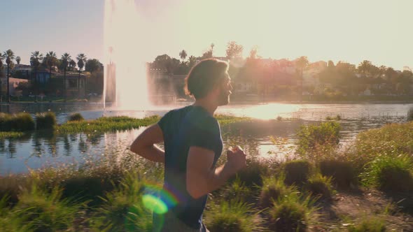 Athletic Man Jogging Around A Small Lake