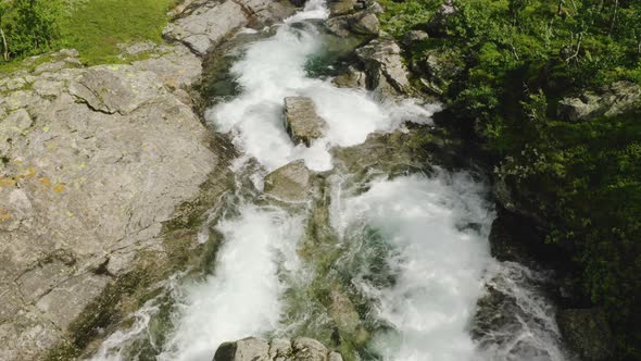 Water Flowing At The Rocky Stream On A Sunny Day In Hydalen Valley, Hemsedal, Norway. - aerial panni