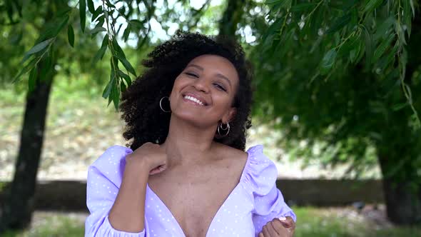 Energetic Black Woman Is Dancing Outdoors and Looking at Camera, Portrait Shot