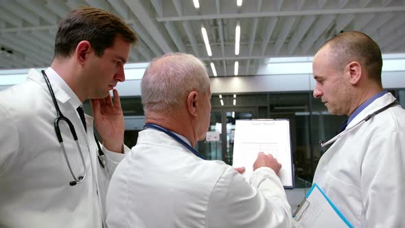 Team of doctors discussing over clipboard