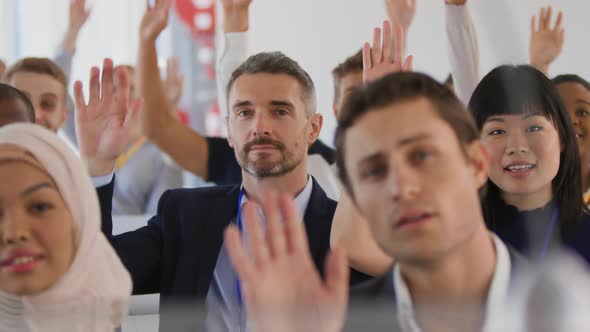 Audience at a seminar raising hands to ask questions