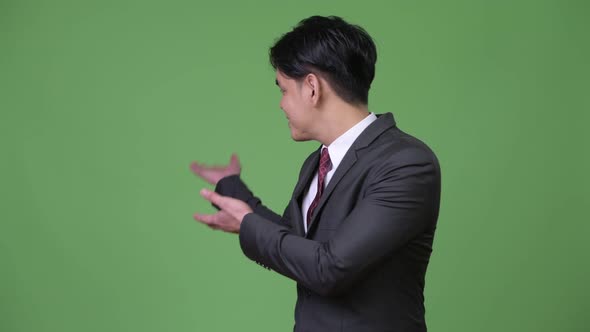 Young Handsome Asian Businessman Showing Something