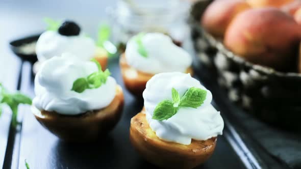Grilled organic peaches with whipped cream, and garnished with fresh mint.