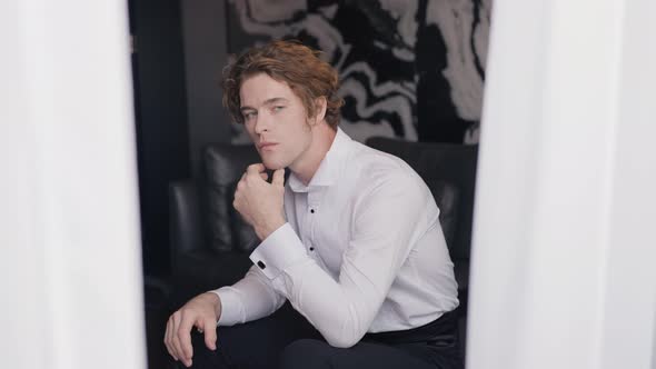 Handsome Young Man in Suit Looks Out Window