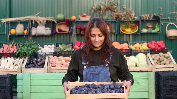 Woman Farmer (Seller) With Plums at the Farmer's Market.