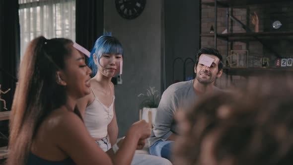 Friends Enjoying Game with Beer Bottles at Home Party