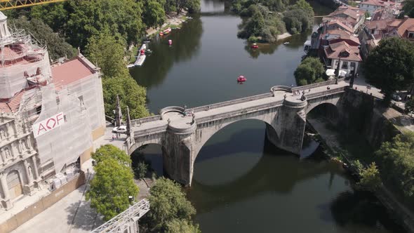 Historical stone bridge over river with cityscape view of Amarante town, aerial orbit view