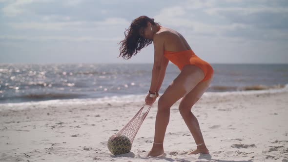 Woman in Swimsuit with Watermelon on the Beach Outdoors