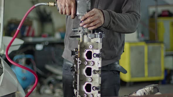 Car Master In Repair Shop Repairing Cylinder Head Of Car Engine On Workbench 2