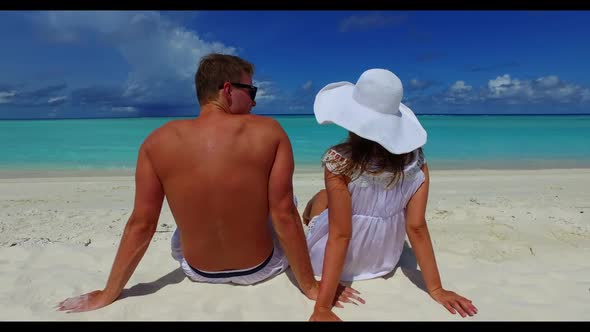 Young couple engaged on luxury island beach adventure by transparent ocean and white sand background