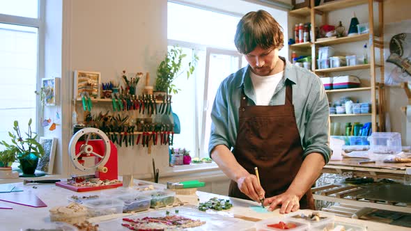 Young man cutting a piece of glass