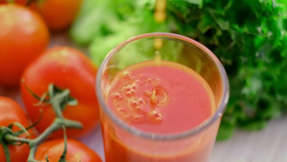 Slow Motion Drops of Tomato Juice Dripping Into a Glass of Juice