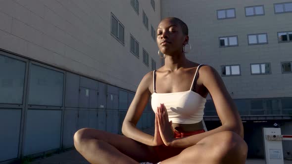 Slow motion shot of young woman meditating while sitting outdoors