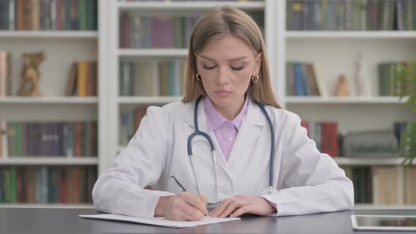 Lady Doctor Writing on Paper in Clinic