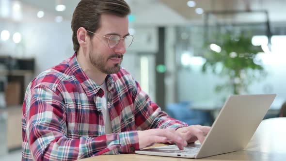 Focused Male Designer Working on Laptop