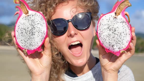 Young Woman With Dragon Pitaya Fruit Eyes On Beach