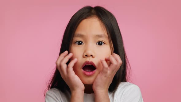 Surprised Korean Little Girl Touching Face In Shock Pink Background