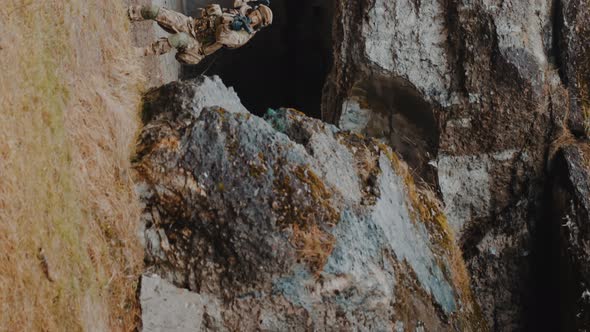 Vertical Shot  Vigilant Soldiers Entering Cave Territory of Rebels