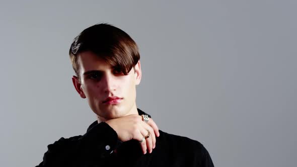 Androgynous man posing against grey background