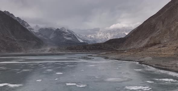 Aerial view, flying directly on a drone over the frozen Lake Karakoram Highway, Hunza Valley In Gilg