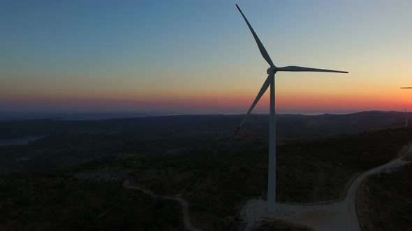 Aerial view of a white big windmill at colorful sunset