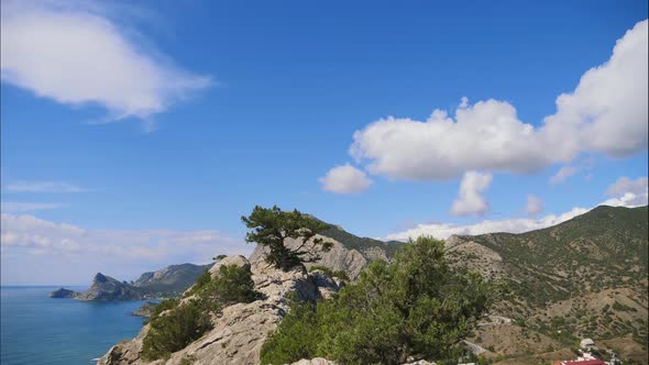 Mountains Against the Blue Sky with White Clouds. Sirus Clouds Run Across the Blue Sky. Tree on the