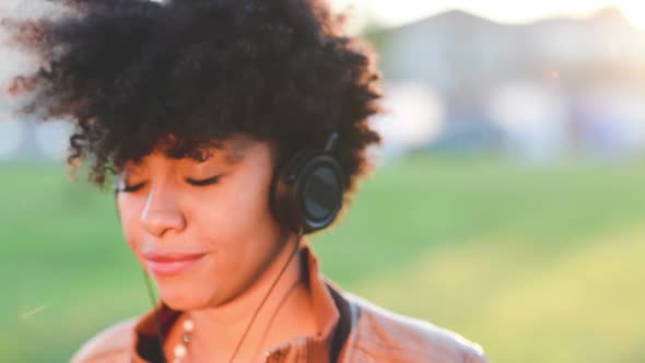 Portrait young black woman listening music serene