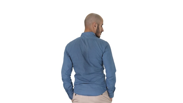 Arab in casual looking around with hands in pockets on