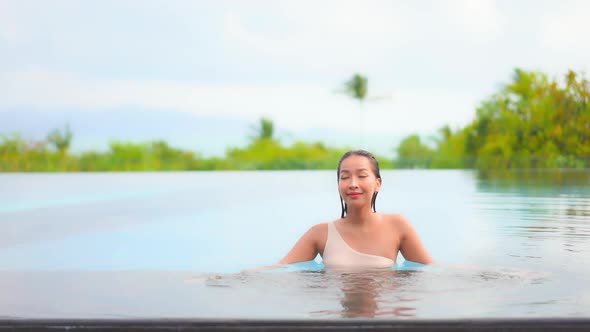 Young asian woman enjoy around outdoor swimming pool for leisure