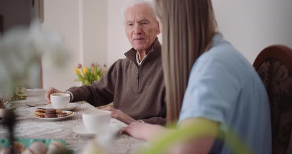 Happy Easter - Grandfather and Granddaughter Spending Easter Together Talking at Home.