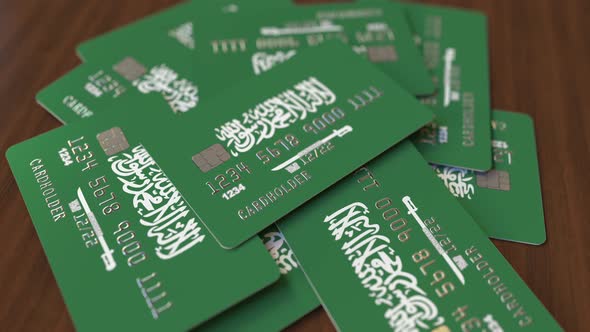 Pile of Credit Cards with Flag of Saudi Arabia. National Banking System Conceptual