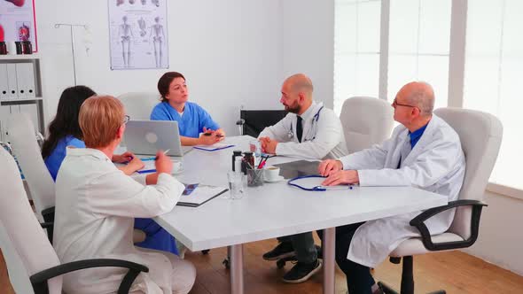 Team of Expert Doctors Having a Briefing in Hospital Conference Room