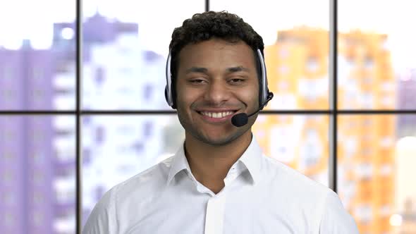 Portrait of a Young Darkskinned Guy Wearing Headset and Smiling with Teeth