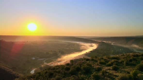 Aerial drone view of the Old Orhei at sunset. Valley with river and fog, village, monastery located 