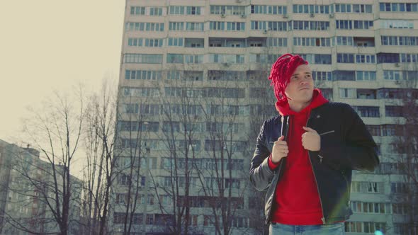 Stylish Man in Trendy Outfit and with Red Dreadlocks Standing on Street