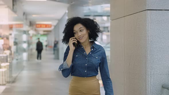 Smiling African American Woman Talking on the Phone in the Mall
