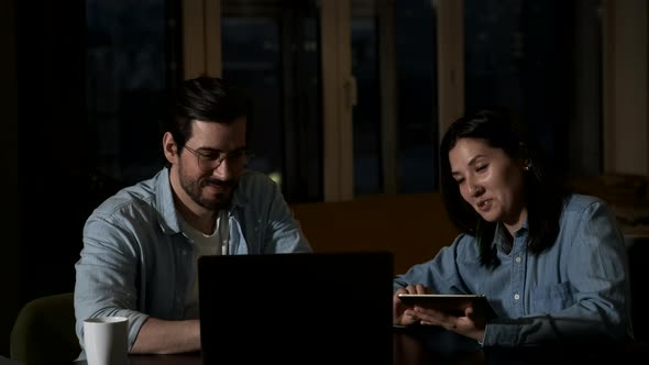 Happy woman and man working with laptop and tablet at home office online